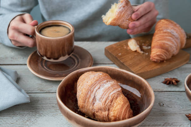 istock The girl drinks coffee and eats croissants. Fragrant stimulating drink. Fresh bakery. Breakfast, snack. 1390261083