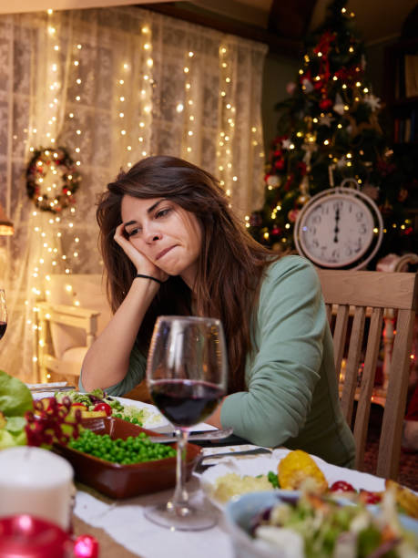 istock Sad woman alone on New Year's Eve at dining table. 1390262209