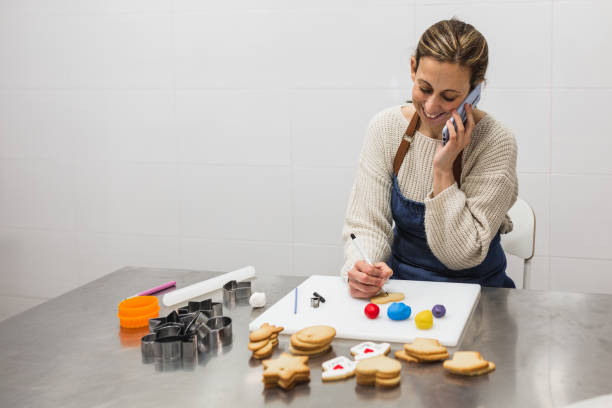 istock Happy baker speaking on smartphone in bakery 1390263812