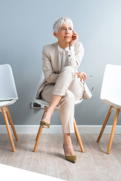 istock Businesswoman looking thoughtful while waiting in line against a grey background 1390265333