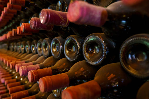 istock Red wrapped wine bottles stacked in a cellar 1390267034