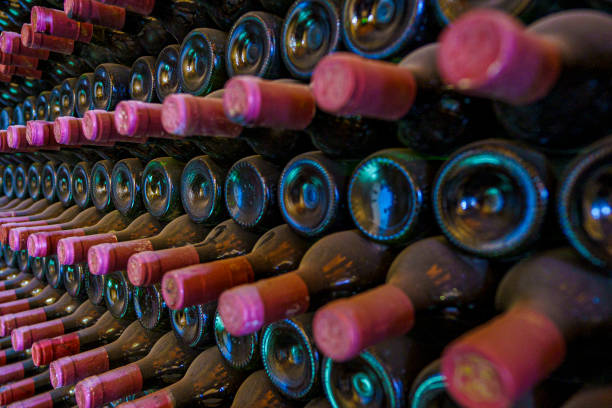 red wrapped wine bottles stacked in a cellar - wine bottle wine wood bottle stopper imagens e fotografias de stock