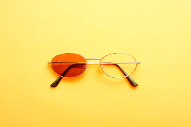 istock Sunglasses with one missing lens on yellow background. 1390267380
