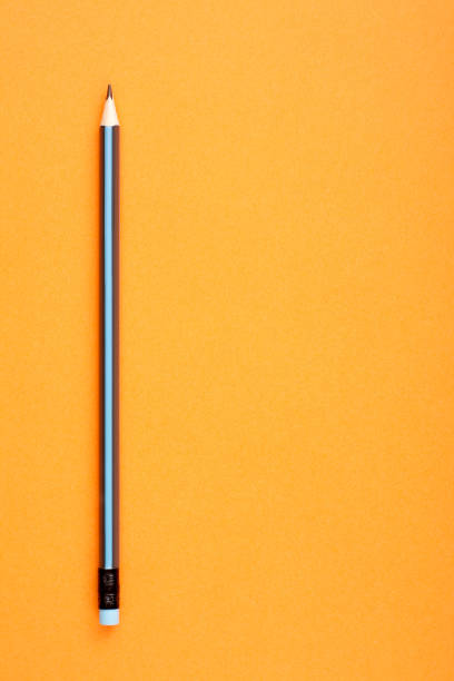 istock Black and blue pencil on orange background with empty copy space for text. 1390267392