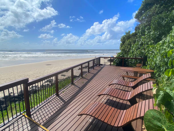 istock Brown timber deck chairs on a timber floor with fence around it.  Overlooking Greenmount Beach and the ocean.  Green trees surrounding the area. Greenmount Gold Coast Queensland Australia 1390268220