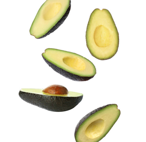 istock Falling fresh ripe avocados on white background 1390275157
