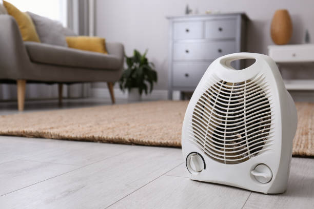 Modern electric fan heater on floor at home. Space for text Modern electric fan heater on floor at home. Space for text radiator stock pictures, royalty-free photos & images