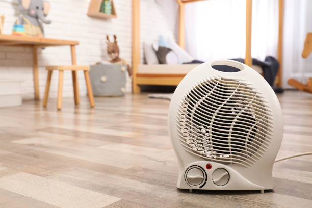 istock Modern electric fan heater on floor at home. Space for text 1390276711