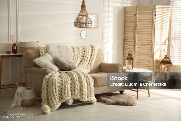 Cozy Living Room Interior With Beige Sofa Knitted Blanket And Cushions Stock Photo - Download Image Now