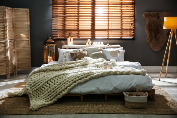 istock Cozy bedroom interior with knitted blanket and cushions 1390277127