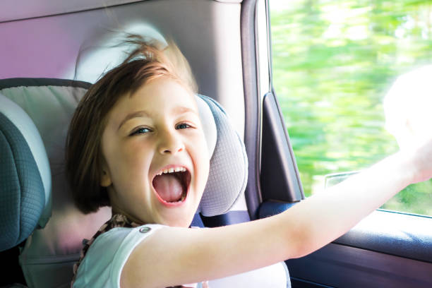 Happy Girl in Car Near Open Window Little happy girl  in a car near the open window. Kid on a road trip. Shallow depth of field. dispelled stock pictures, royalty-free photos & images