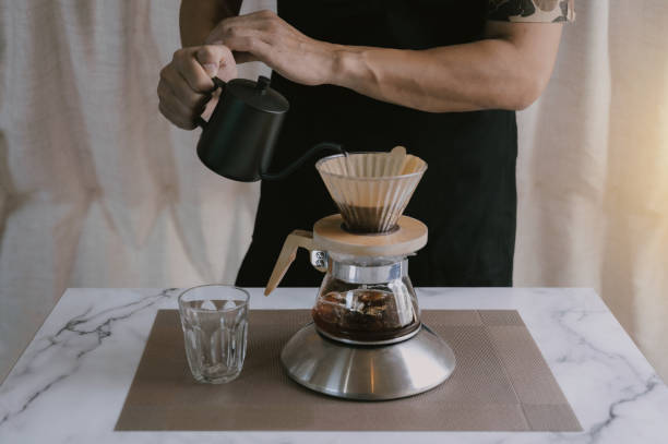 istock Close-up coffee maker that is professionally extracting coffee by barista with a deep white glass in the evening sun light. coffee, extraction, deep, machine, make, barista concept. 1390280759