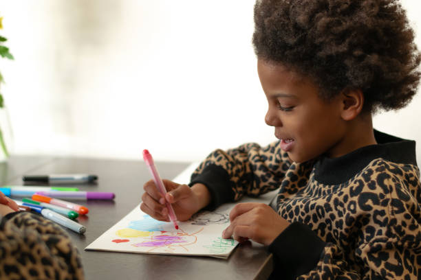 African-American girl are drawing with felt-tip pens together with her caucasian mother at home.Diverse people.Time together.