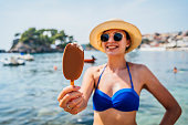 Woman on beach eating ice cream