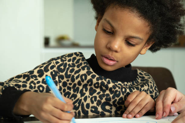 African-American girl are drawing with felt-tip pens together with her caucasian mother at home.Diverse people.Time together.