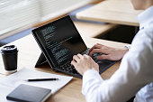 istock Asian programmer writing code on a laptop 1390285717