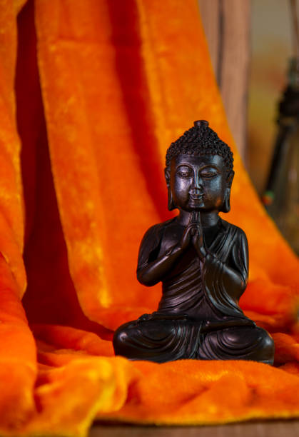 istock Buddha with candlelight and decoration on golden fabric - selective focus 1390291050