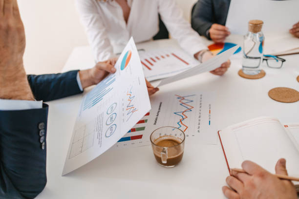 istock Close-up of a messy conference table. Papers, charts and hands 1390291072