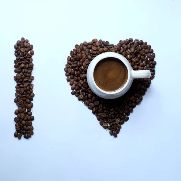 a cup of black coffee with a heart shaped coffee bean background