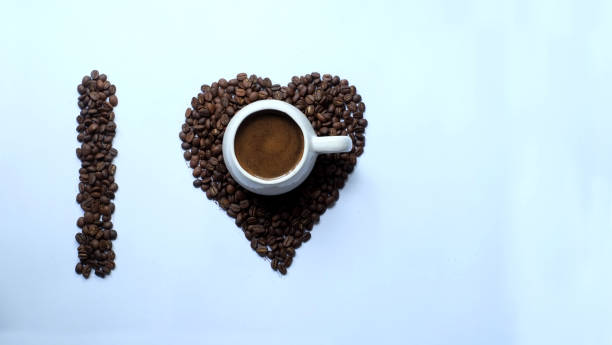 istock a cup of black coffee with a heart shaped coffee bean background 1390295284