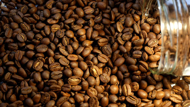 istock Close-up of coffee beans spilling from jar 1390296180