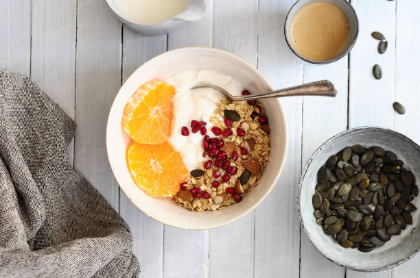 Oatmeal with yogurt, almonds and pomegranate in a bowl standing on a table