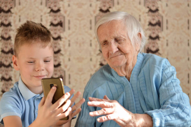 istock An elderly 90-year-old woman wearing a blue jacket smiles using a smartphone. 1390297251