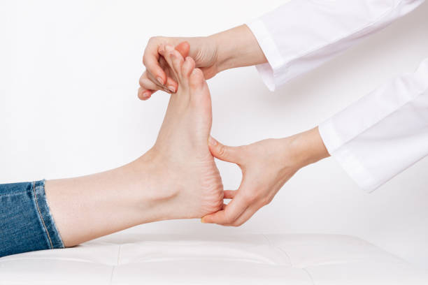 examination of a young woman by orthopedist. cropped shot of female doctor holding girl's foot - plattfot bildbanksfoton och bilder