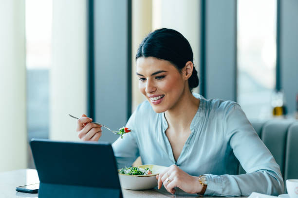 istock Smiling Businesswoman Using Digital Tablet in the Restaurant 1390298219