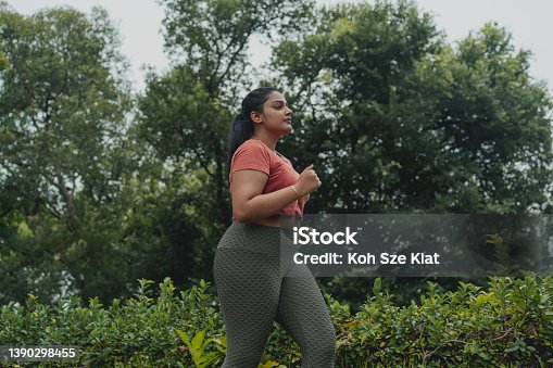 istock Asian Indian body-positive woman jogging in an outdoor park 1390298455
