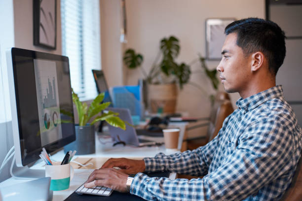 istock A businessman sits at his office desk analysing a data report with graphs 1390299246
