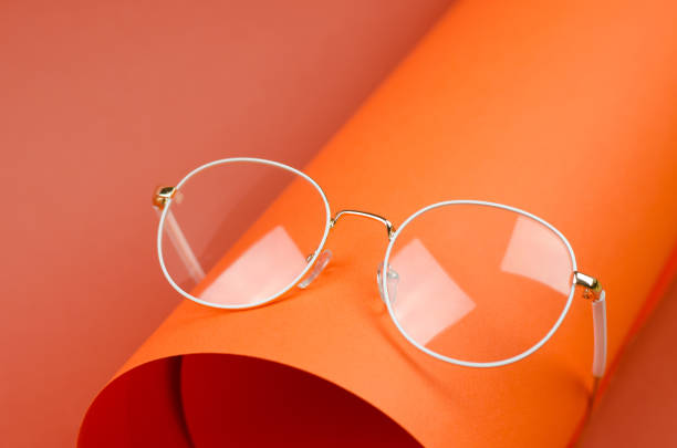 istock Stylish women's eyeglasses in a white frame on an orange background 1390299900