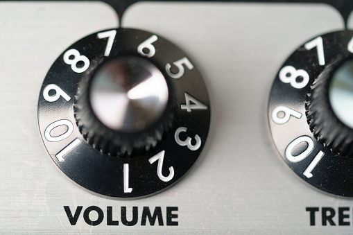 Volume control knob of a black amplifier on audio mixing console volume in a stereo