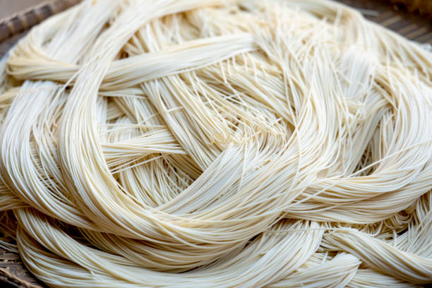 Fresh Dried noodles on drying rack. Outdoor Chinese Traditional Local Homemade Noodle Factory. Fresh Dried noodles on drying rack. Outdoor Chinese Traditional Local Homemade Noodle Factory. Yellow pasta Or egg noodles background texture pattern. Instant Mee Sua Chinese noodles Handmade. NOODLES stock pictures, royalty-free photos & images
