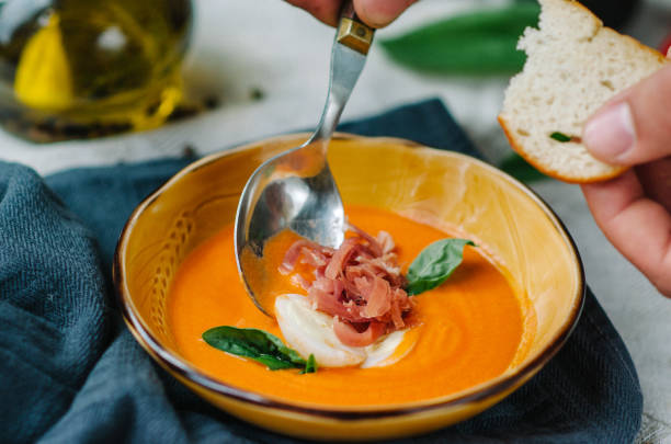 cold spanish tomato soup salmorejo garnished with hard-boiled egg wedges and slices of smoked ham and basil. soup tasting with toast. - basil tomato soup food and drink imagens e fotografias de stock