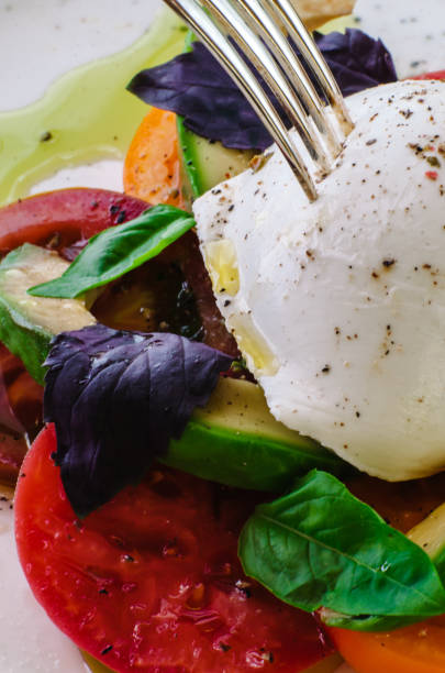 istock Buffalo burrata cheese served with fresh raw tomatoes and basil leaves 1390301789
