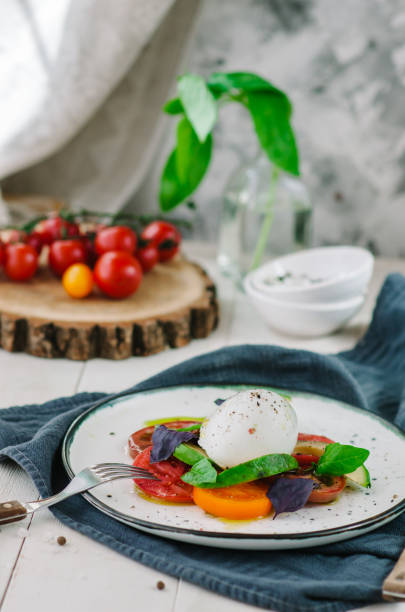 istock Buffalo burrata cheese served with fresh raw tomatoes and basil leaves 1390301806