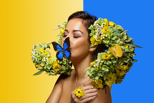 Studio portrait of a beautiful brunette Flower Queen wearing a unique headpiece with Ukrainian colours