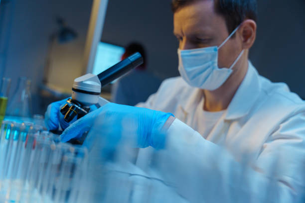 istock A white man in a lab coat, working with a microscope in a modern scientific laboratory 1390303317