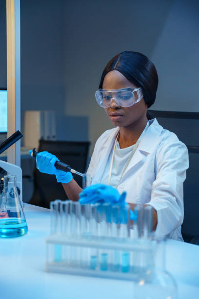 istock A young beautiful African-American scientist in protective glasses works with automatic pipette in a modern laboratory 1390303364