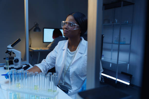istock A beautiful smiling  African-American scientist at work, she is looking away sitting at her desk in a modern lab 1390303487