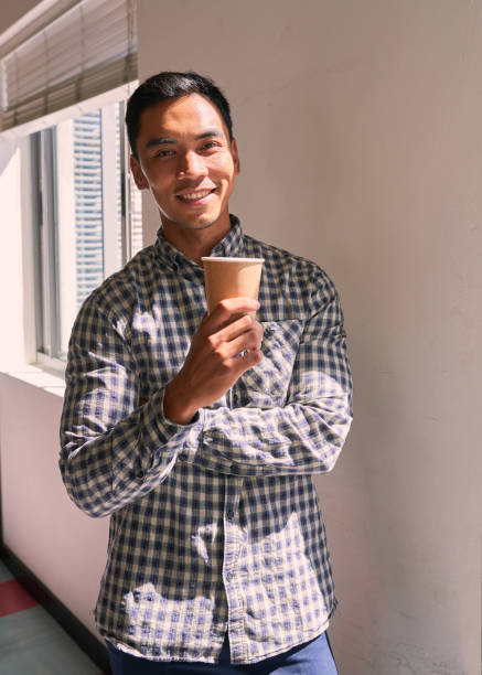 istock A young businessman drinks coffee and smiles in the office 1390303538