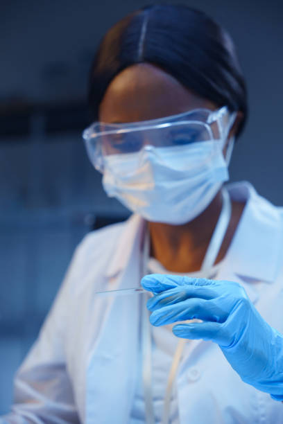 istock A young  African-American scientist holding a  microscope slide, working in a modern laboratory 1390303567