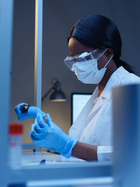 istock A young  African-American doctor is working with a mechanic micropipette and a microscope slide in a modern laboratory 1390303572