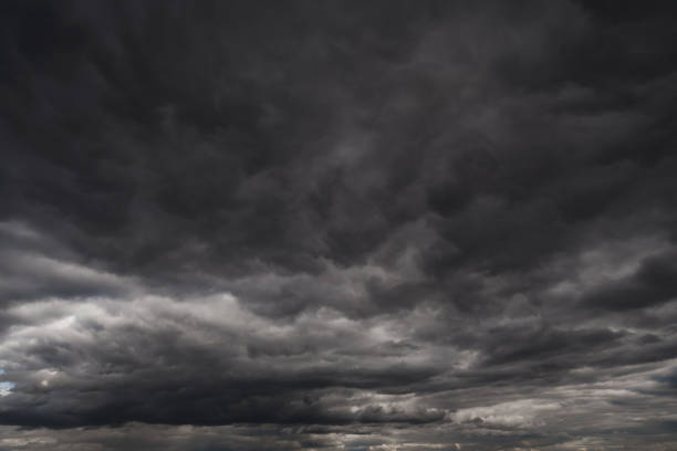 background of dark dramatic sky with stormy clouds before rain or snow, extreme weather background of dark dramatic sky with stormy clouds before rain or snow, extreme weather stratus clouds stock pictures, royalty-free photos & images