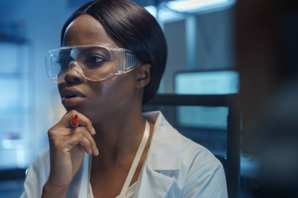 istock A young smart African-American scientist is thinking about a  solution of a chemical reaction written on a glass board in front of her in a modern laboratory 1390304577