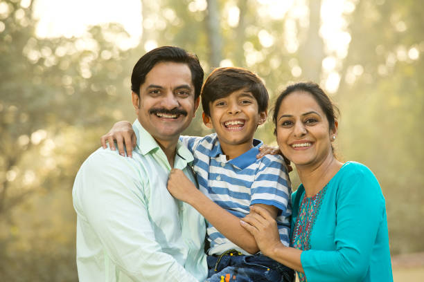Happy family admiring view at park Loving mother and father spending leisure time with son at park happy indian young family couple stock pictures, royalty-free photos & images