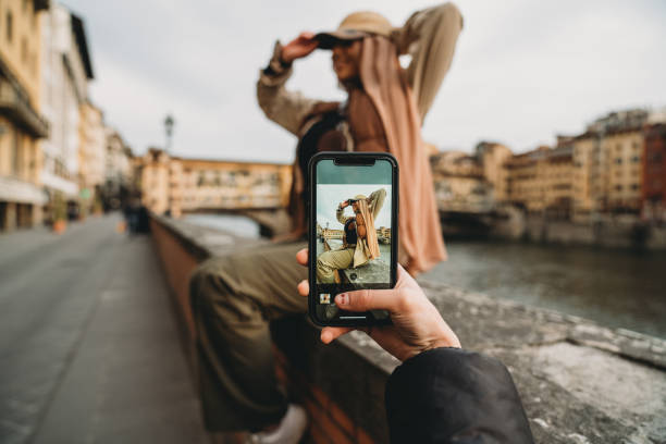 A young adult woman is taking a picture to her friends A young adult woman is taking a picture to her friends. They are sharing their travel on social media. Pov view. muslim photographer stock pictures, royalty-free photos & images