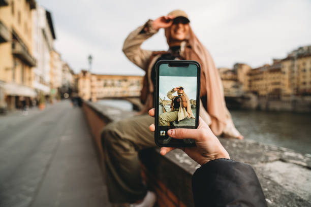 una joven adulta está tomando una foto a sus amigos - mensaje de móvil fotografías e imágenes de stock
