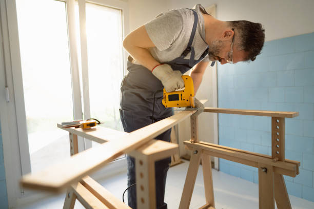 istock Caucasian carpenter using jigsaw to cut the timber 1390310551